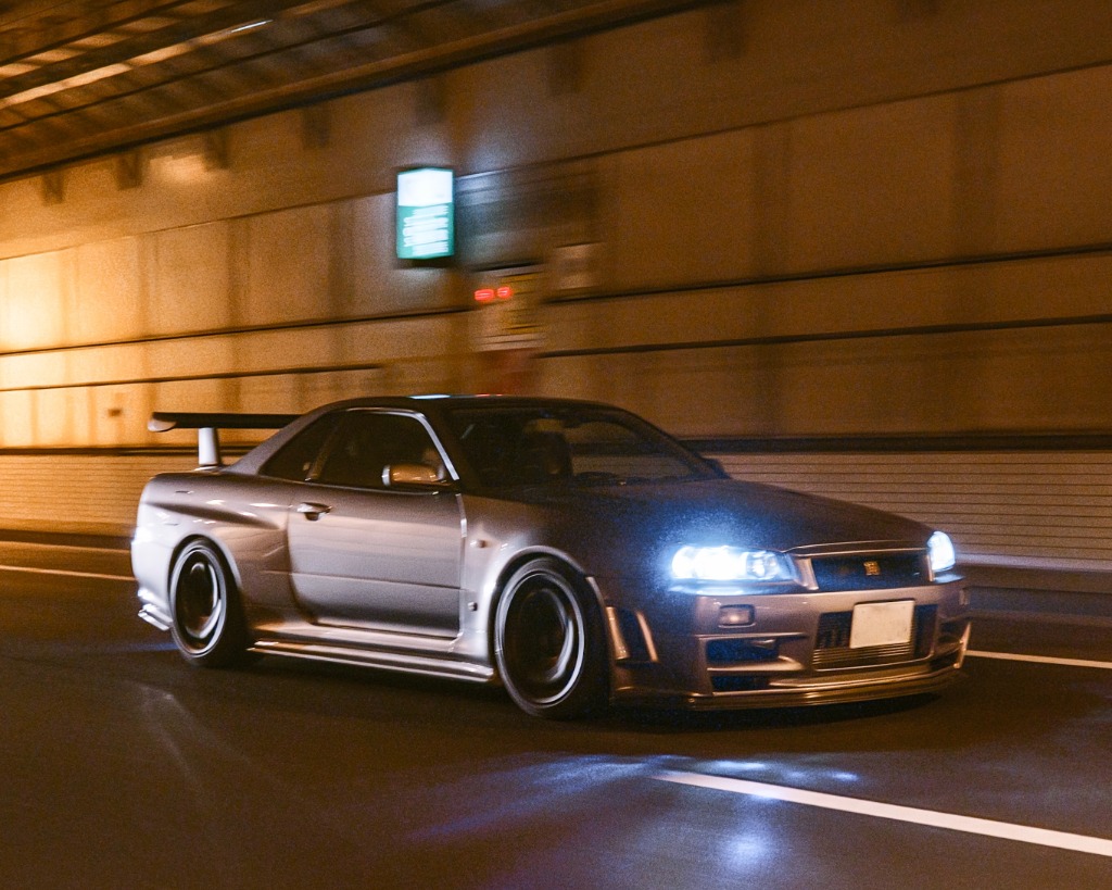 Silver R34 GT-R driving through tunnel